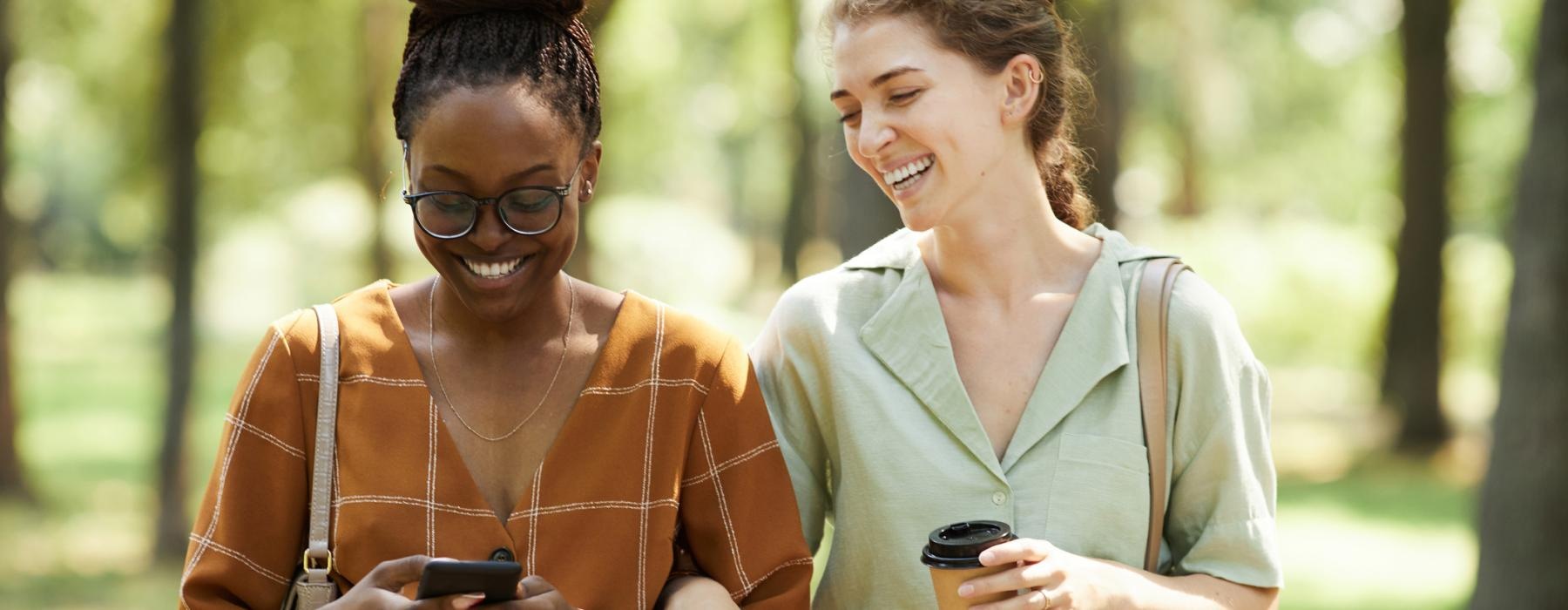 a couple of women looking at a cell phone