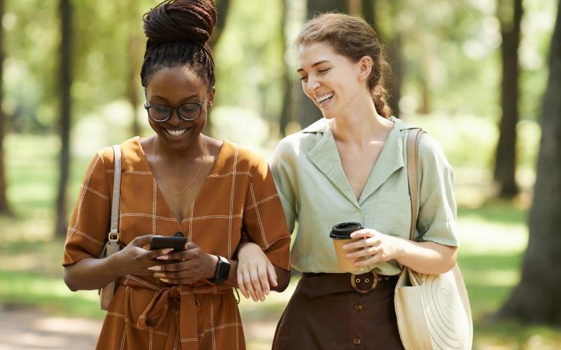 a couple of women looking at a cell phone