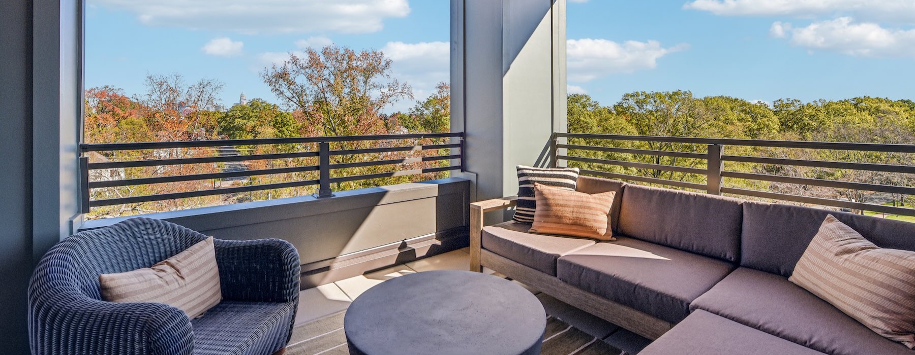 a deck with a couch, chair and a view